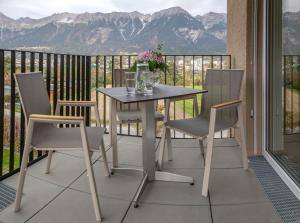 a table and chairs on a balcony with mountains at Apartments Ella in Innsbruck