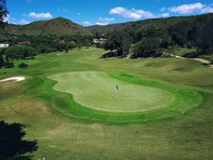 una vista aérea de un golfista en un campo de golf verde en Saint Michel Unidad Superior en Alta Gracia