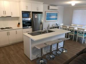 a kitchen with a sink and a counter with bar stools at Moontana in Port Moonta