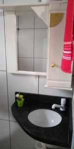 baño con lavabo y toalla roja en Lar doce lar, en Florianópolis