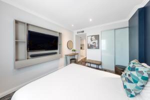 a bedroom with a large bed and a flat screen tv at Club Wyndham Sydney, Trademark Collection by Wyndham in Sydney