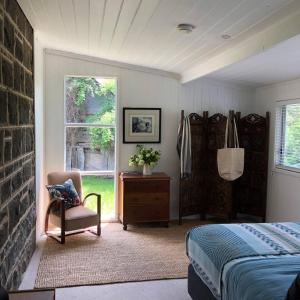 ein Schlafzimmer mit einem Bett, einem Stuhl und einem Fenster in der Unterkunft Ellerslie Cottage in Metcalfe