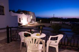 a table and chairs on a balcony at night at Sophi's L Studios & Apartments in Agia Anna Naxos