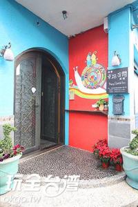 une porte d'entrée d'un bâtiment avec un panneau sur celui-ci dans l'établissement Happiness Space, à Hengchun Old Town