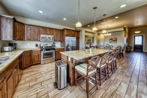 a kitchen with wooden cabinets and a large island with bar stools at Mountain View Retreat: Paradise Village at Zion #39 in Santa Clara