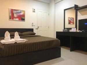 um quarto com uma cama com toalhas e um espelho em Me Apartment em Ban Talat Rangsit