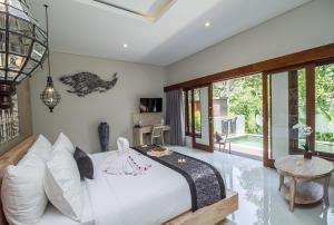a bedroom with a white bed and a table at Ubud Hills Villas & Resort in Ubud