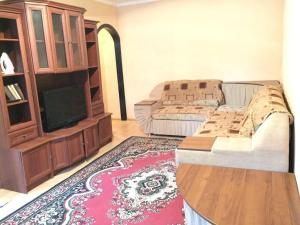 a living room with a couch and a tv at Apartment in 2 mikrorayon in Almaty