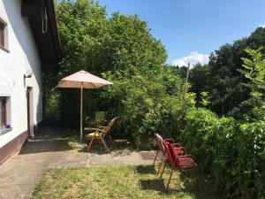 a patio with a table and chairs and an umbrella at Burgruine Schöllnstein in Iggensbach