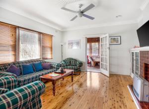 ein Wohnzimmer mit einem Sofa und einem Tisch in der Unterkunft The Summit House in Katoomba
