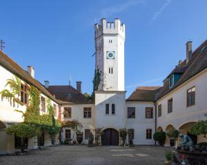 a building with a tower with a clock on it at Schloss - Schenke Tunzenberg in Mengkofen