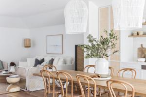 uma sala de estar com uma mesa de madeira e cadeiras em Cape Beach House em Byron Bay