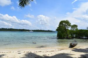 a beach with a boat in the water at Sundaze Beach Resort in Havelock Island