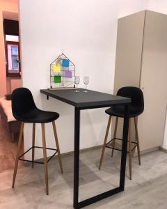 czarny stół z dwoma krzesłami i szklanką w obiekcie Apartment VIP Ploscha Rynok w Lwowie
