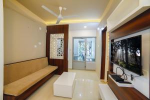 a living room with a couch and a flat screen tv at Ambalath Maple Leaves Home in Guruvāyūr