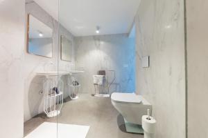 a white bathroom with a toilet and a sink at Sea Lovers Apartment in Alcudia +35 photos