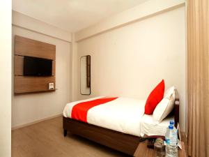 a bedroom with a bed and a tv on the wall at OYO 626 Hotel Himchuli in Kathmandu