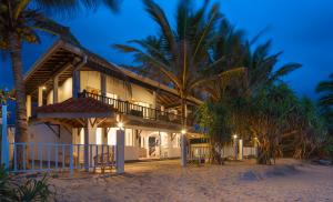 a resort on the beach at night with palm trees at Villa Mer Vue in Ambalangoda