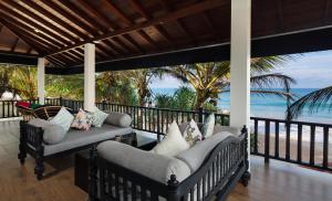 a porch with chairs and the ocean in the background at Villa Mer Vue in Ambalangoda