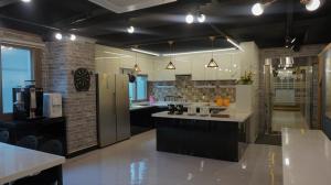 a large kitchen with black cabinets and a counter top at Sh Guesthouse in Chuncheon