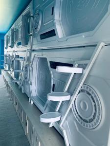 a row of washers and dryers on a wall at Capsule Inn Bali in Legian