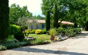 a garden in front of a house with trees and plants at Les gites de Lescurou in Limogne-en-Quercy