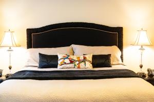 een slaapkamer met een groot bed met 2 lampen bij Camas Boutique Hotel in Camas