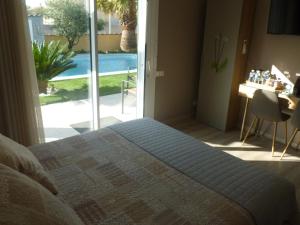 a bedroom with a bed and a view of a pool at Chambre avec charme in Garons