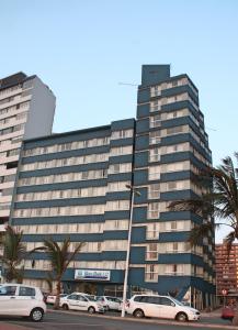 a large building with cars parked in front of it at Gooderson Leisure Silver Sands 2 Self Catering and Timeshare Lifestyle Resort in Durban