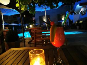 a drink sitting on a table next to a candle at The Mathraki Studios (Adult Only) in Arillas