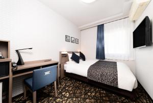 a hotel room with a bed and a desk at HOTEL MYSTAYS Aomori Station in Aomori