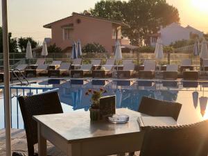 - une table et des chaises à côté de la piscine dans l'établissement Hotel Coral Beach, à Roda