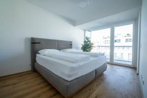 a bedroom with a large bed and a large window at Moderne trifft Tradition im Herzen Wiens in Vienna