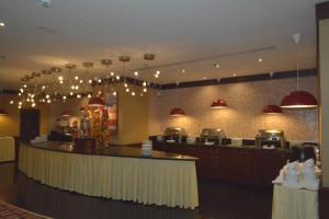 a restaurant with a bar with lights on the wall at Al Jaad Mahbas Hotel in Makkah