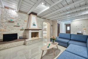 un salon avec un canapé bleu et une cheminée dans l'établissement Villa Stagio, à Alykes