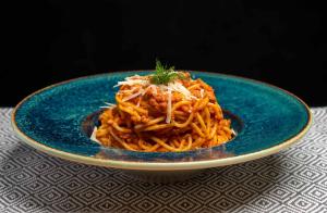 ein blauer Teller Spaghetti auf einem Tisch in der Unterkunft Labirint Boutique Hotel - Central Location in Bukarest + 39 Fotos