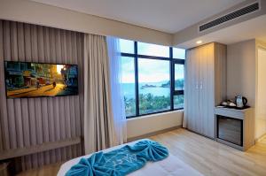 - une chambre avec un lit et une grande fenêtre dans l'établissement The MCR Luxury Nha Trang, à Nha Trang