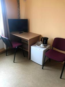 een kamer met 2 stoelen en een bureau met een magnetron bij Kambarių nuoma - Neveronys SAURIDA in Neveronys