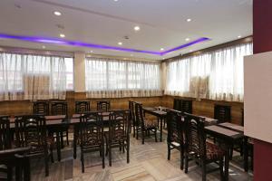 Diamond Plaza في كولْكاتا: غرفة طعام مع طاولات وكراسي ونوافذ