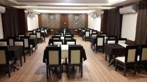 a large room with tables and chairs in it at Lijoy Hotel & Restra in Būndi