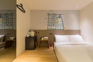 a hotel room with a bed and a desk at Chaiin Hotel - Dongmen in Taipei
