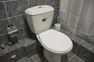 a white toilet sitting in a bathroom next to a sink at Astana Hotel in Almaty