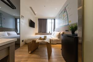 a hotel room with a bed and a table at Chaiin Hotel - Dongmen in Taipei