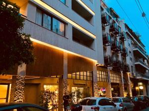 ein Gebäude mit davor geparkten Autos in der Unterkunft Athens Studios in Athen