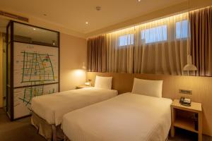 a hotel room with two beds and a window at Chaiin Hotel - Dongmen in Taipei
