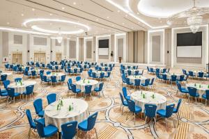 un gran salón de banquetes con mesas y sillas azules en Radisson Blu Plaza Jeddah, en Yeda