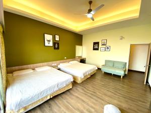 a bedroom with two beds and a blue chair at I WoW in Xiaoliuqiu