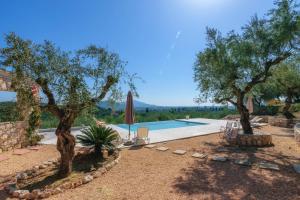 an external view of a villa with a swimming pool and trees at Ville Du Coop in Zakynthos Town