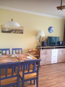 a dining room with a table and a tv at Ferienwohnung Haus Rügen in Göhren