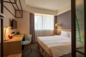 a hotel room with a bed and a desk at Chaiin Hotel - Dongmen in Taipei
